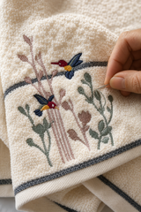 Hand-finished floral and bird embroidery on a Willow & Fern cotton towel
